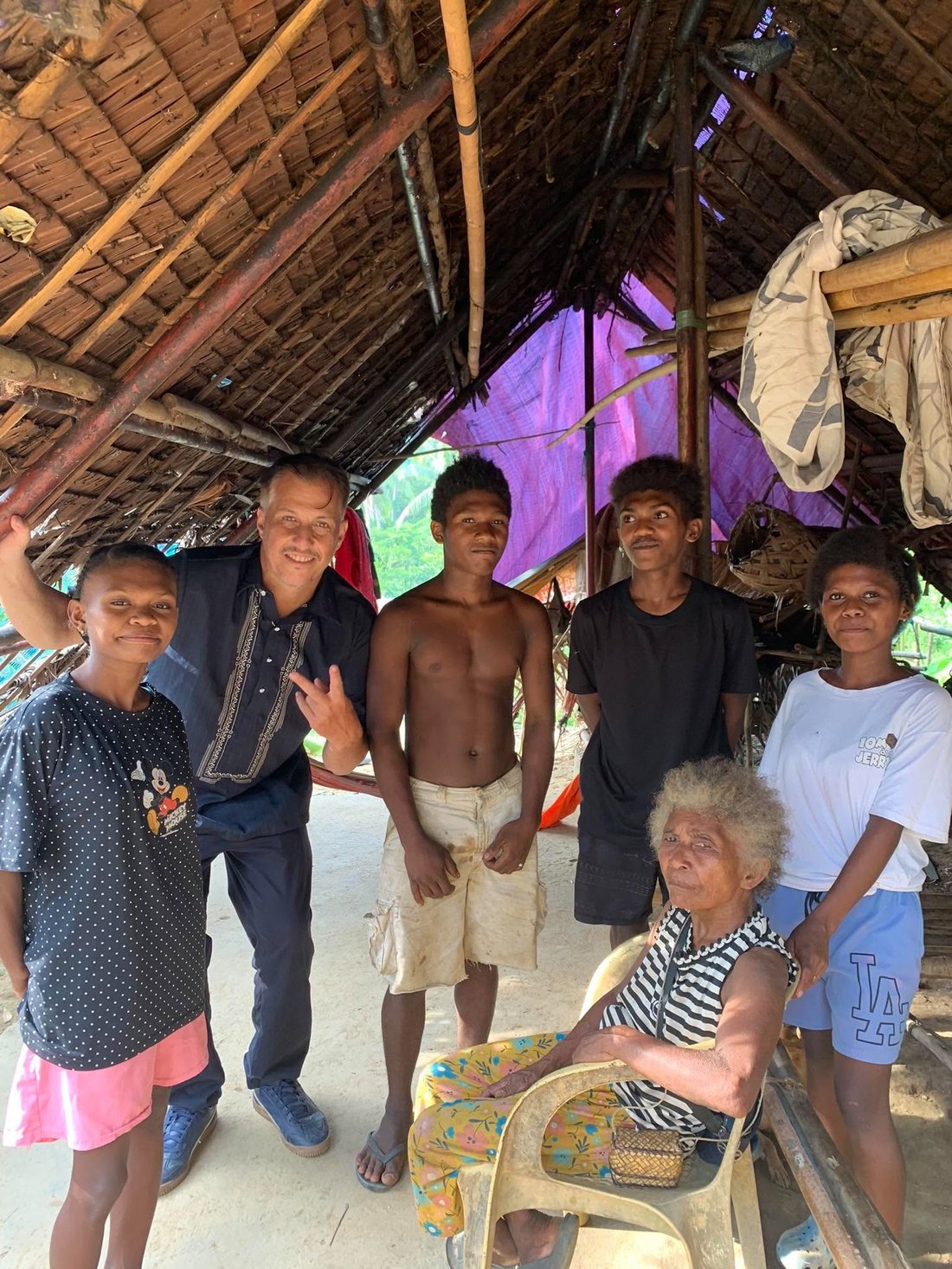 An Aeta family in their home in Tumbaga, San Rafael, with a visitor from the Inocalla mining and farming community