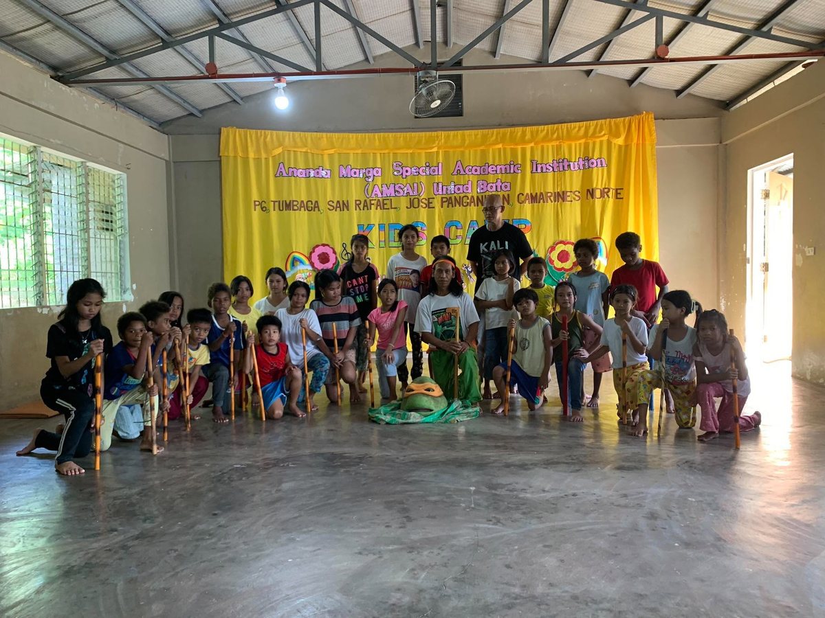 Children with Arnis sticks and their instructors at the AMSAI Kids Camp in Tumbaga, San Rafael, Jose Panganiban