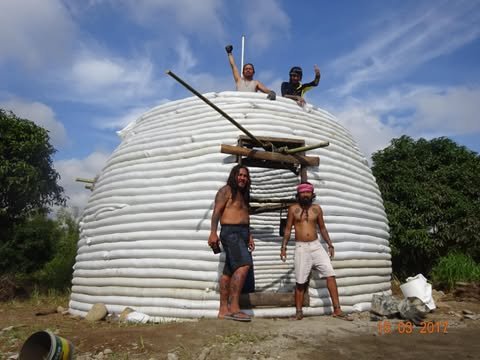 Volunteers on and in front of a finished earthbag dome